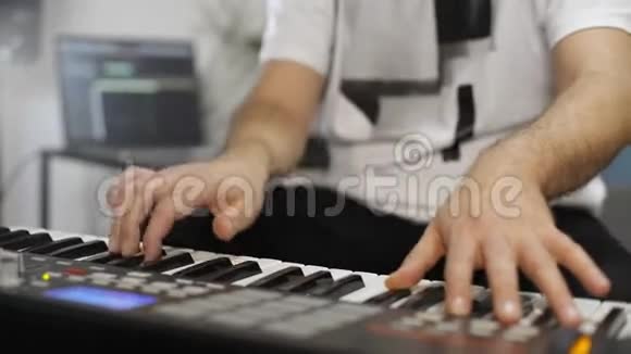 音乐家在家庭音乐工作室演奏MIDI键盘时手腕疼痛视频的预览图
