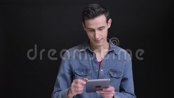 用平板电脑为年轻的高加索帅哥特写肖像并自信地向相机显示绿色屏幕视频的预览图