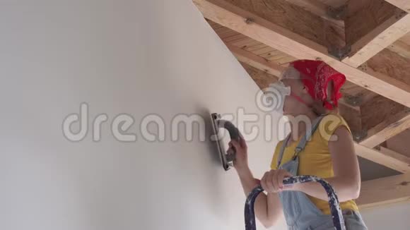 在公寓里修理一位欧洲貌美的年轻女子在家里修理墙面抛光视频的预览图