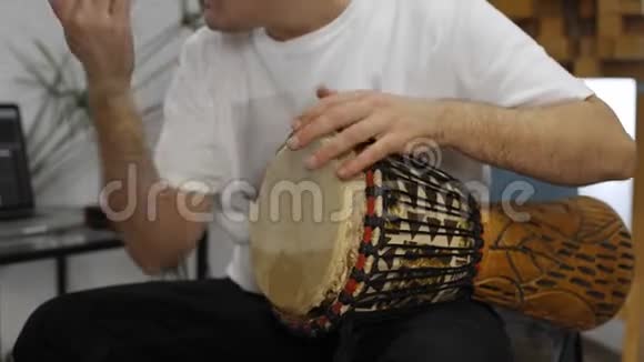 在家庭音乐工作室演奏djembe鼓乐器时手腕疼痛的音乐家视频的预览图