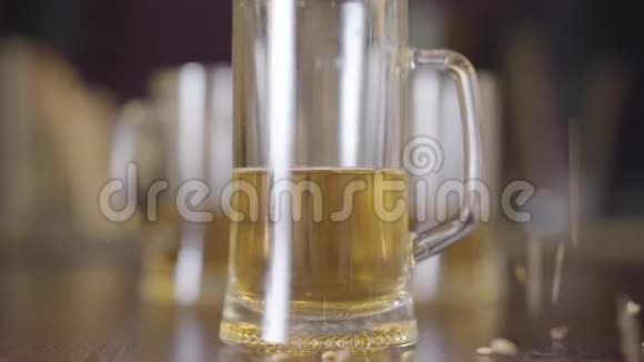 酒吧特写中站在桌子上的那杯啤酒大麦种子洒在玻璃旁边天然啤酒视频的预览图