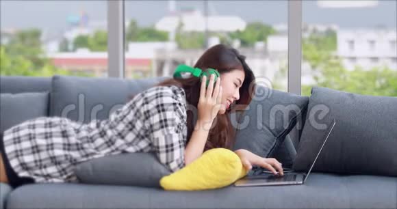 亚洲女人躺在大玻璃窗附近的沙发上视频的预览图