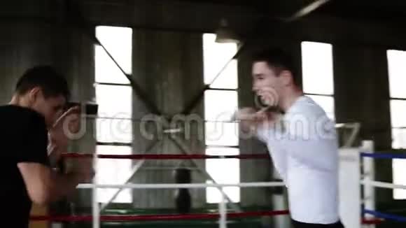 这位年轻的拳击手反映了他的对手在健身房的拳击场上的攻击他们玩得很开心没有互相攻击视频的预览图