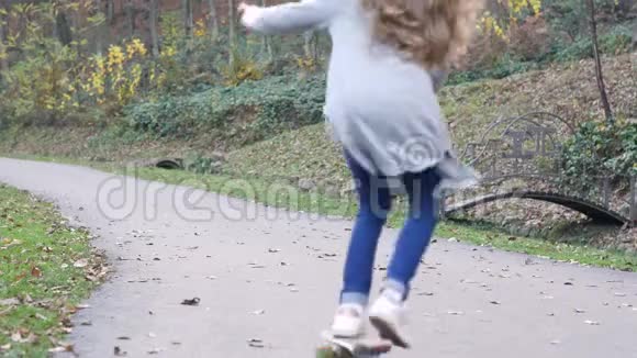 在森林附近的小路上看到一个女孩在玩滑板视频的预览图