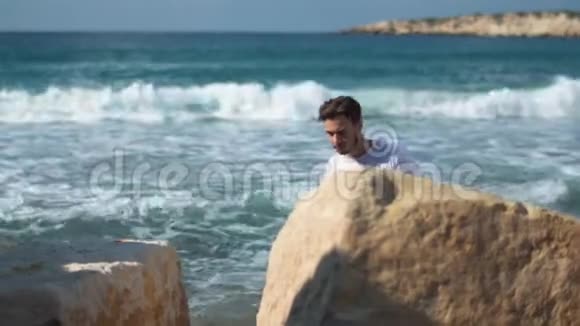 年轻英俊的男人在神奇的海边攀岩景色很美视频的预览图