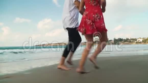 不认识的一对夫妇在海边奔跑手牵手视频的预览图