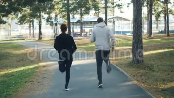 后景美女夫妇一起在公园跑步穿着时髦的运动服和运动鞋积极主动视频的预览图