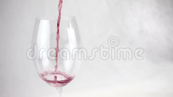 葡萄酒倒入白色背景上透明的大玻璃杯中视频的预览图