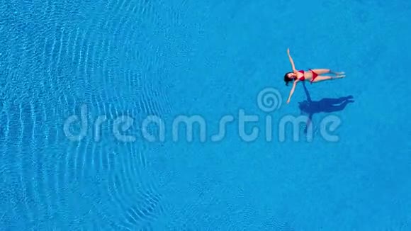 从顶部看一个穿红色泳衣的女人在游泳池里仰泳视频的预览图