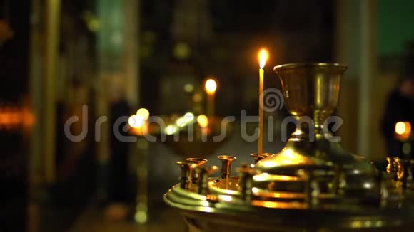 一支小蜡烛在一个大烛台上矗立在东正教教堂里视频的预览图