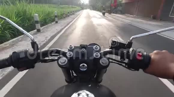 视角POV拍摄的男子骑经典摩托车以村景为主视频的预览图