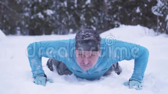 冬天的森林里一个冻僵的被霜冻覆盖的人在雪地上推视频的预览图