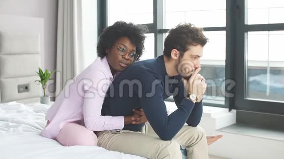 一个体贴的白人男人在她的非洲女友坐在后面时有压力视频的预览图