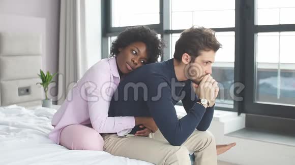 漂亮的非洲女孩在家里沙发上安慰她心烦意乱的男朋友视频的预览图