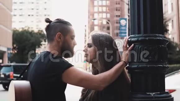 年轻的时髦夫妇在繁忙的城市街道接吻浪漫的男人和女孩和咖啡站在一起4K浪漫视频的预览图