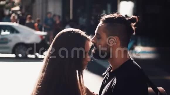 年轻夫妇在阳光明媚的街道上拥抱和亲吻公车经过欧洲男人和女孩站在一起看着对方浪漫4K视频的预览图