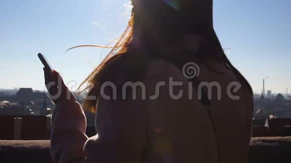 女性在屋顶上看欧洲城市时用手机打电话漫游视频的预览图