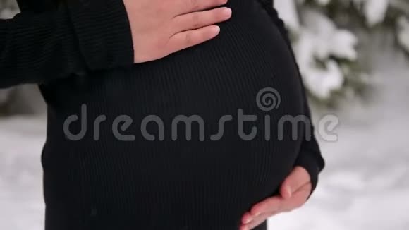 冬季公园里怀孕少女腹部特写视频的预览图