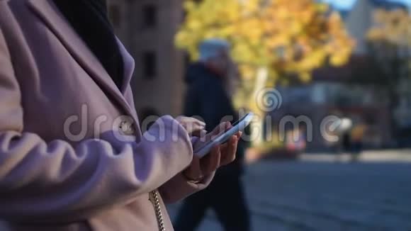 穿着外套的女孩在街上冻僵了打电话叫出租车用在线GPS应用程序找到咖啡馆视频的预览图