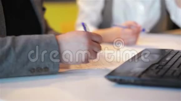 两个商人在AAN办公室围着一张木桌人在纸上写文字视频的预览图