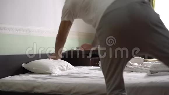 穿着睡衣的帅哥跳上床用毯子盖上被子慢动作视频的预览图