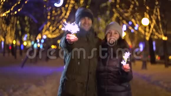 微笑着年轻美丽的幸福夫妇手里拿着火花视频的预览图