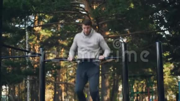 有魅力的家伙正在户外锻炼使用水平杆努力改善肌肉和增加力量视频的预览图