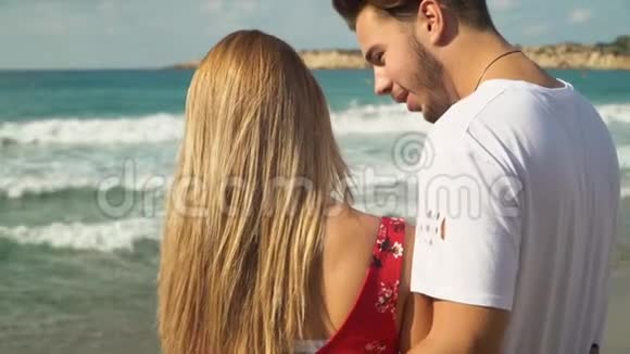 后景美丽的年轻夫妇拥抱在一起在海滩上交谈景色是惊人的视频的预览图