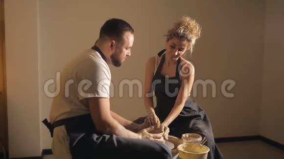 年轻夫妇喜欢在陶器作坊里用粘土干活视频的预览图