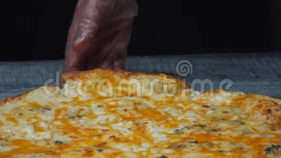 厨师的贴身保护手套取一块美味的4奶酪比萨饼放在木板上框架视频的预览图