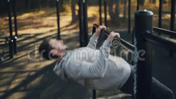 留胡子的家伙正在户外锻炼独自在公园的低水平杆上做拉力练习积极主动视频的预览图