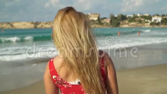 金发女人背对着镜头站着然后转过身来她的头发在缓慢的运动中飘扬孤独女孩视频的预览图