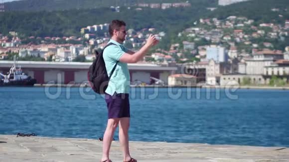 年轻英俊的胡子男在里雅斯特海码头拍户外照片视频的预览图