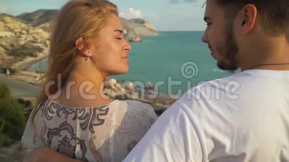 男人和女人坐在长凳上说话美丽的海景就在背景上快乐的一对在一起视频的预览图