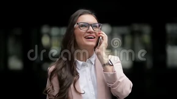 幸福的年轻律师正在电话交谈站在城市大厦的背景白夹克里的白布吕特视频的预览图