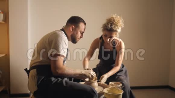恋爱中的浪漫情侣一起工作在陶工轮和雕刻泥壶视频的预览图