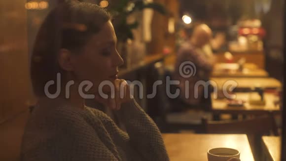 孤独的美女在咖啡馆里看着一对情侣梦想着自己的幸福视频的预览图