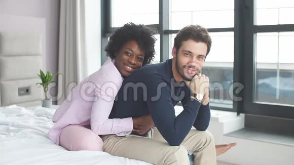 跨种族年轻夫妇在床上放松和享受乐趣视频的预览图