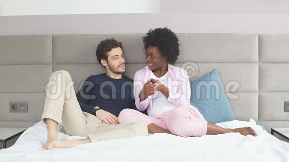 一对混在一起的情侣在床上休息每天一起看电视视频的预览图
