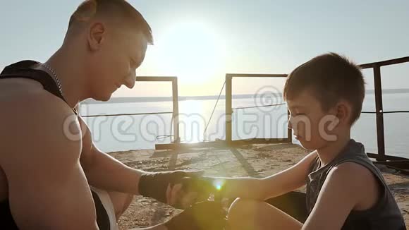 年轻的男拳击运动员拉着他儿子的保护带视频的预览图