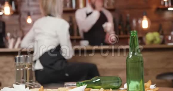 关着的酒吧里脏桌子上的空啤酒瓶视频的预览图