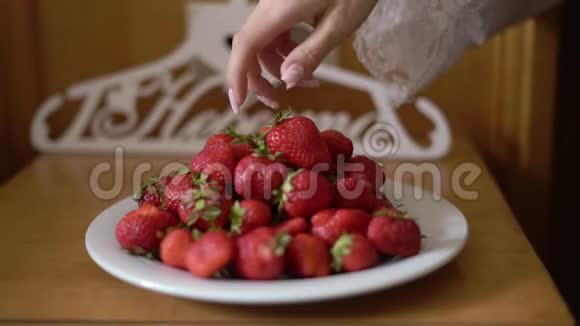 从盘子里拿出红甜草莓吃视频的预览图