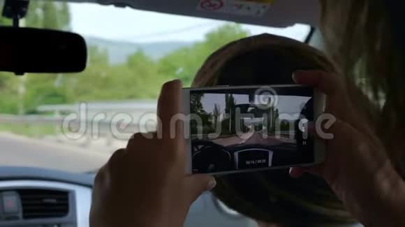 一个女孩在一次汽车旅行中用手机录制视频视频的预览图