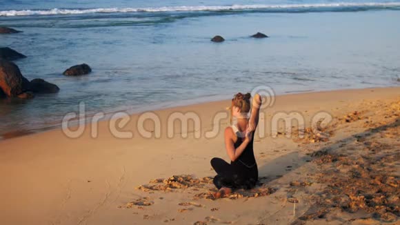 美丽的女孩在黄沙滩练习瑜伽视频的预览图