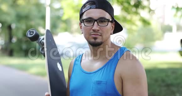 一个戴眼镜的年轻人在户外玩滑板的肖像视频的预览图