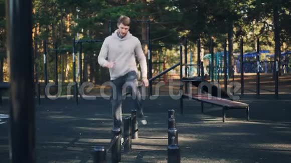 健康的人在户外运动独自在公园锻炼的运动场上踩着金属棒积极青年视频的预览图