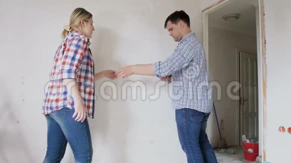 一对年轻夫妇正在用卷尺翻新他们家的墙视频的预览图