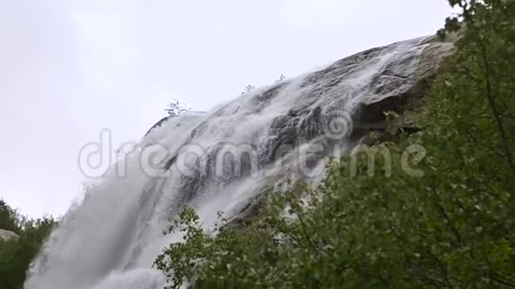 在一片绿色的森林中一个暴风雨的河流瀑布在缓慢的运动中的近距离水滴和喷雾并跟踪视频的预览图