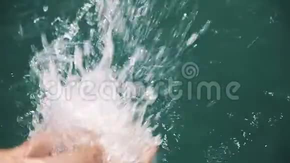 女人的双腿缓慢地在清澈的水里挣扎在阳光下飞溅的水视频的预览图