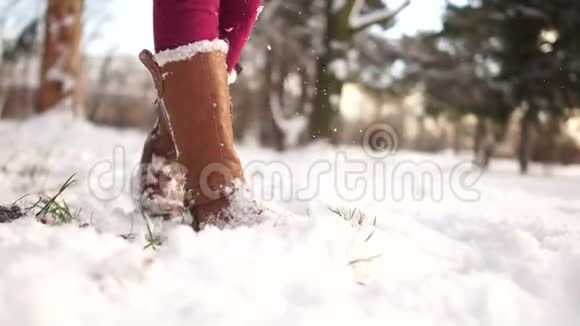在冬天的棕色靴子里雪里有白色的皮毛把雌性的腿弄脏了女孩温暖起来在寒冷的霜冻中跳跃视频的预览图